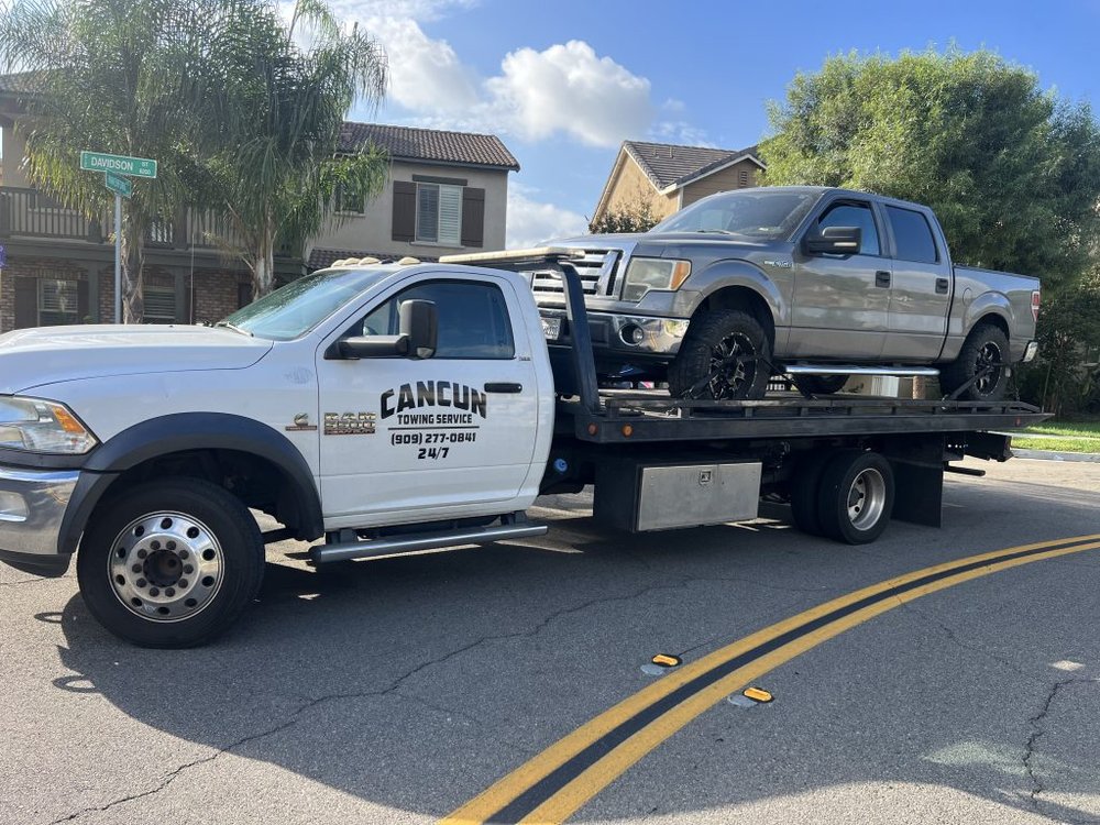 Cancun Towing Service tow truck recovering a pickup on a residential street