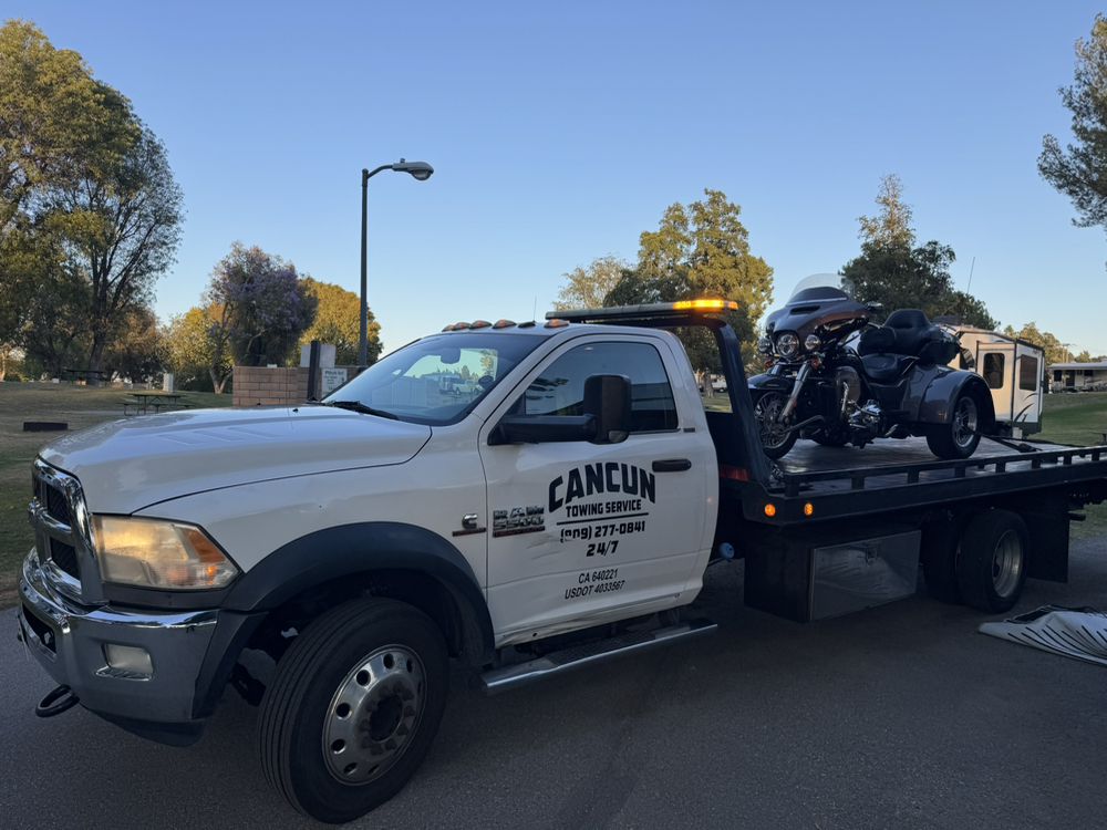 Cancun Towing Service flatbed transporting a motorcycle at sunset